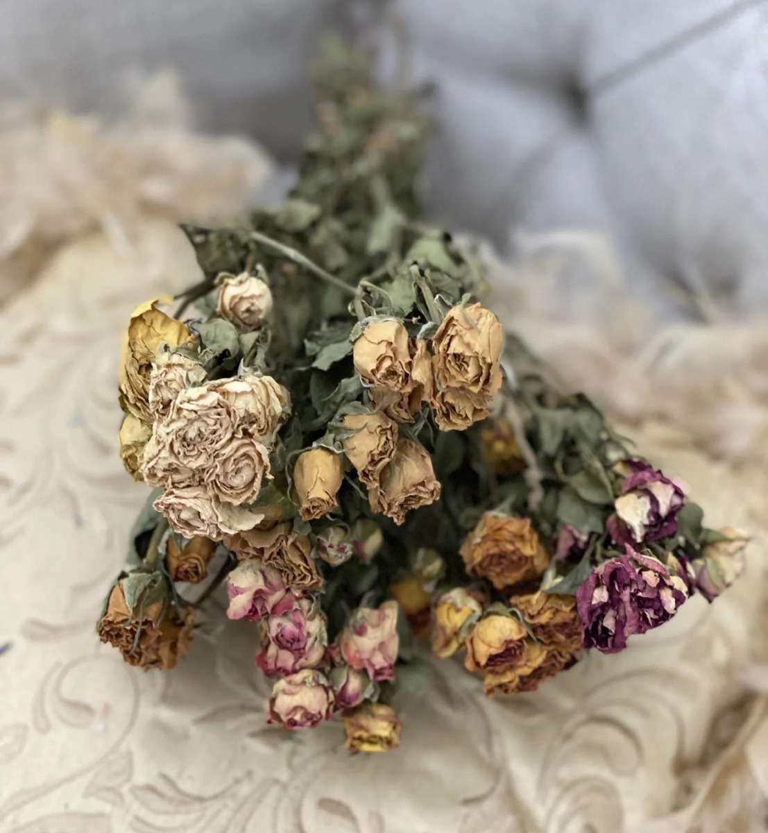 decor de toamnă — buchet de trandafiri miniroze uscați pe masa de sufragerie