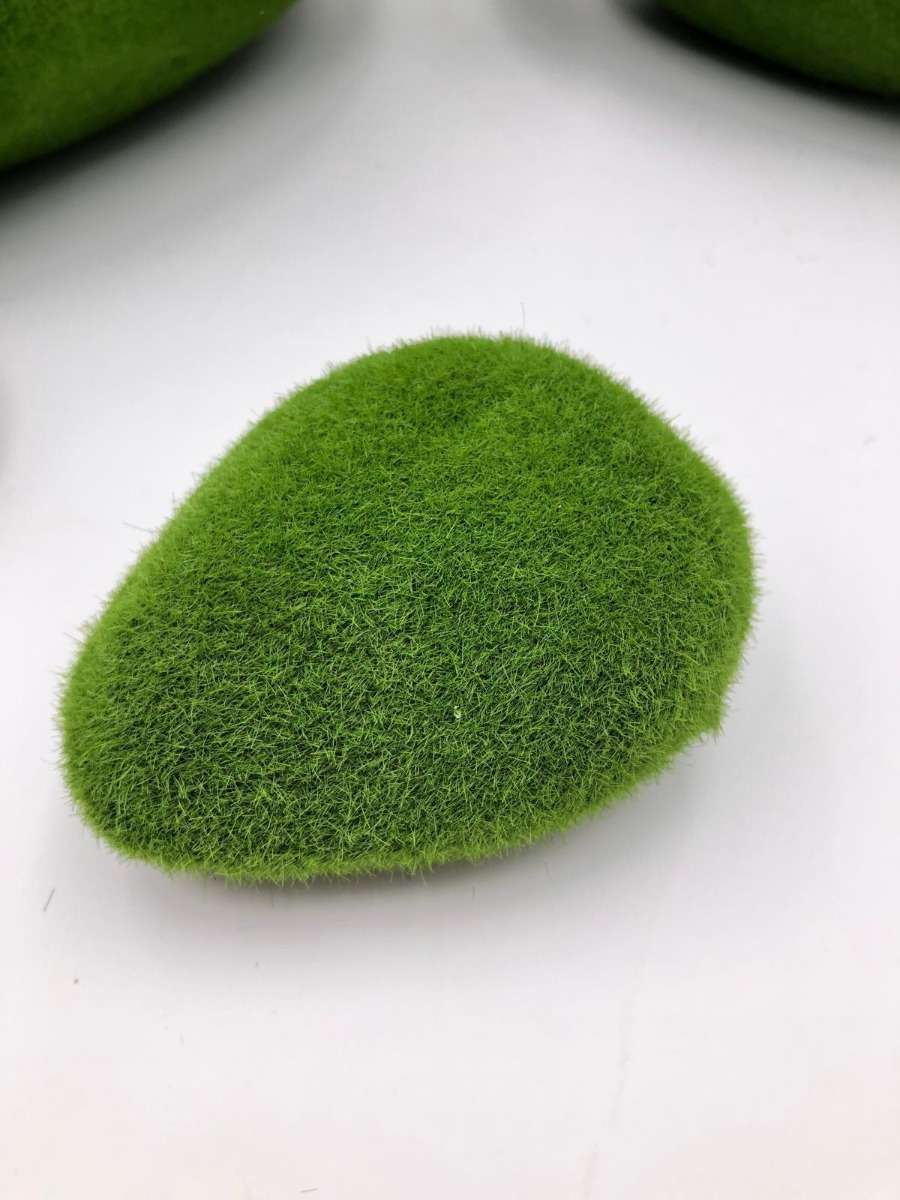 flori artificiale — piatră cu mușchi verde la baza decorului